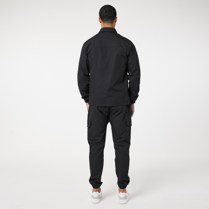 Back profile of men's black overshirt jacket with matching cargo trousers