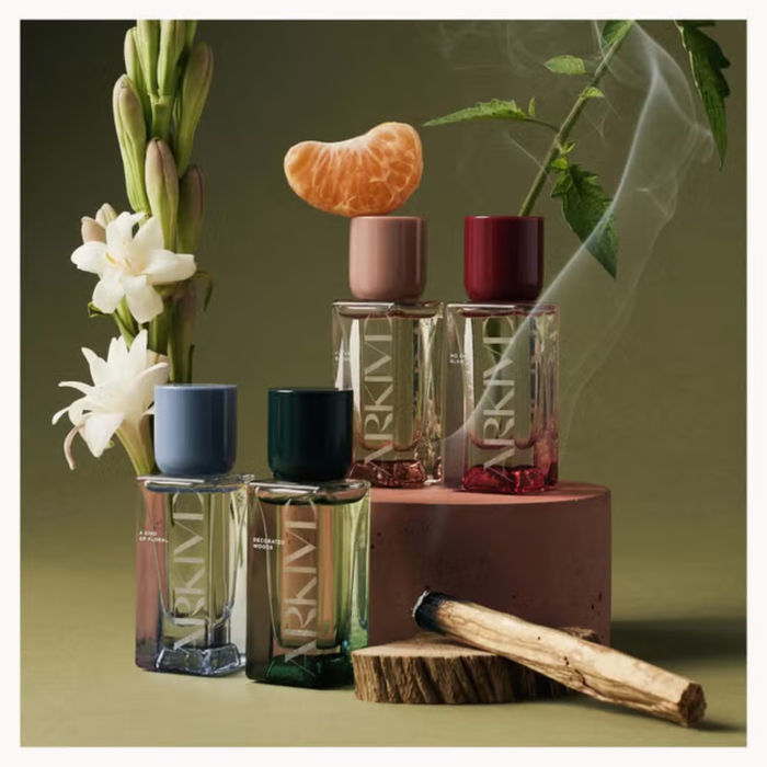 Arkive Fragrance Discovery Collection four EDP bottles on olive green background with florals, citrus, wood and smoke styling