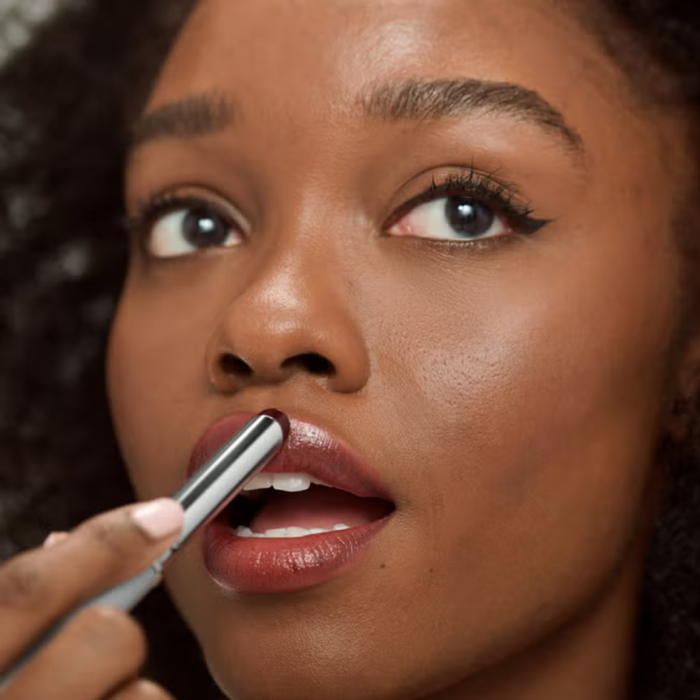 Clinique Cult Classic Lipstick Duo Gift Set applied to model's lips with silver brush, deep berry shade, neutral background