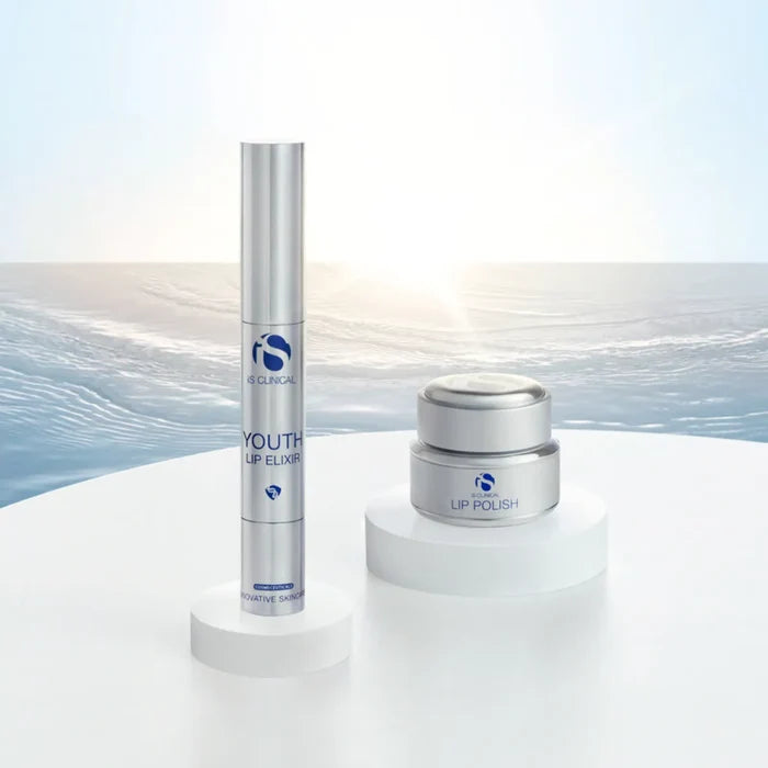 iS Clinical Youth Lip Elixir in silver tube and Lip Polish in silver jar on white platforms with water background