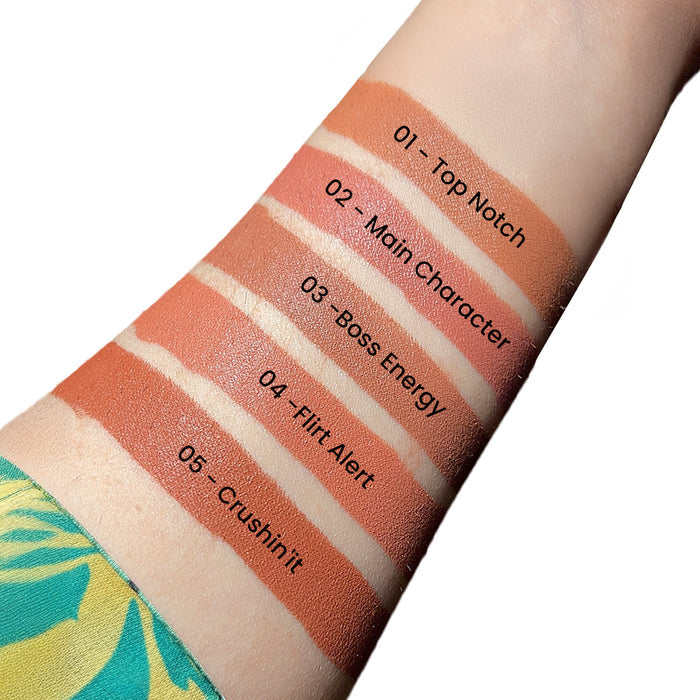 Lipstick swatches on a person's arm with color names labeled