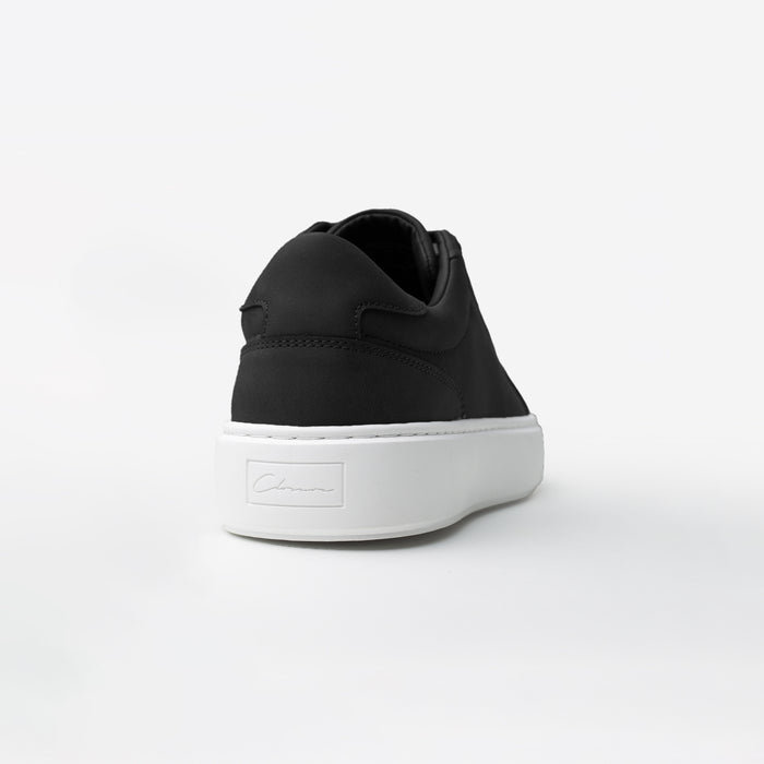 Rear view of the Premium Classic Trainer in black, highlighting the black faux suede heel panel and debossed Signature Closure London branding on the black cup sole.