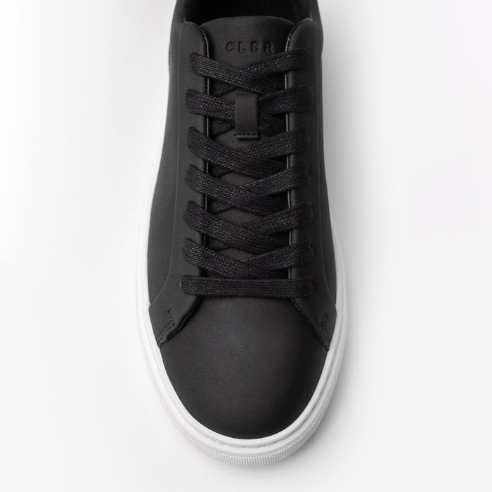 Top-down close-up of the Premium Classic Trainer in black, highlighting the black lace-up fastening, smooth PU upper and stitched toe detailing.