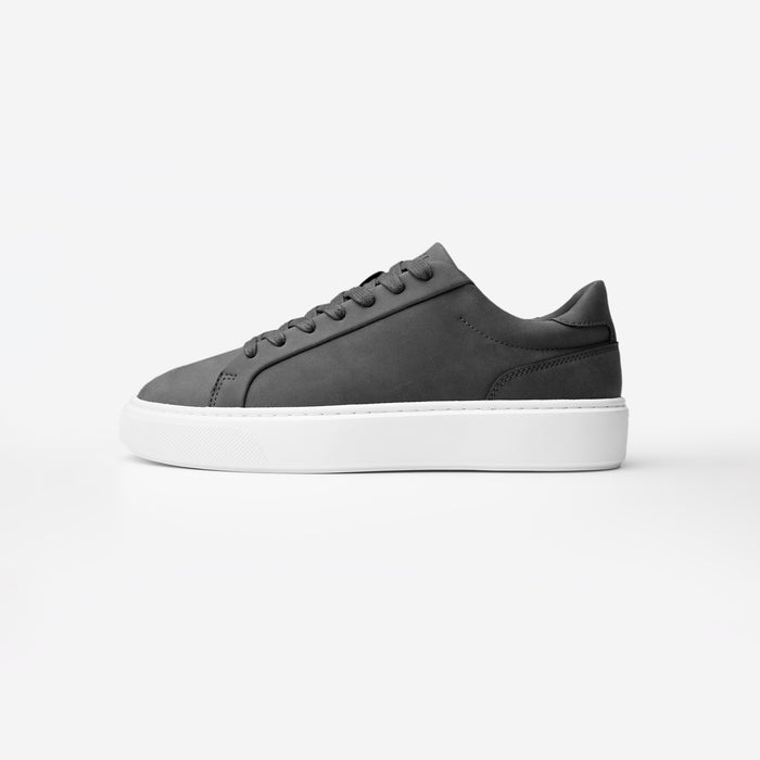 Side view of the Premium Classic Trainer in charcoal, featuring a clean white PU upper, charcoal faux suede heel, charcoal lace-up fastening and cushioned cup sole.