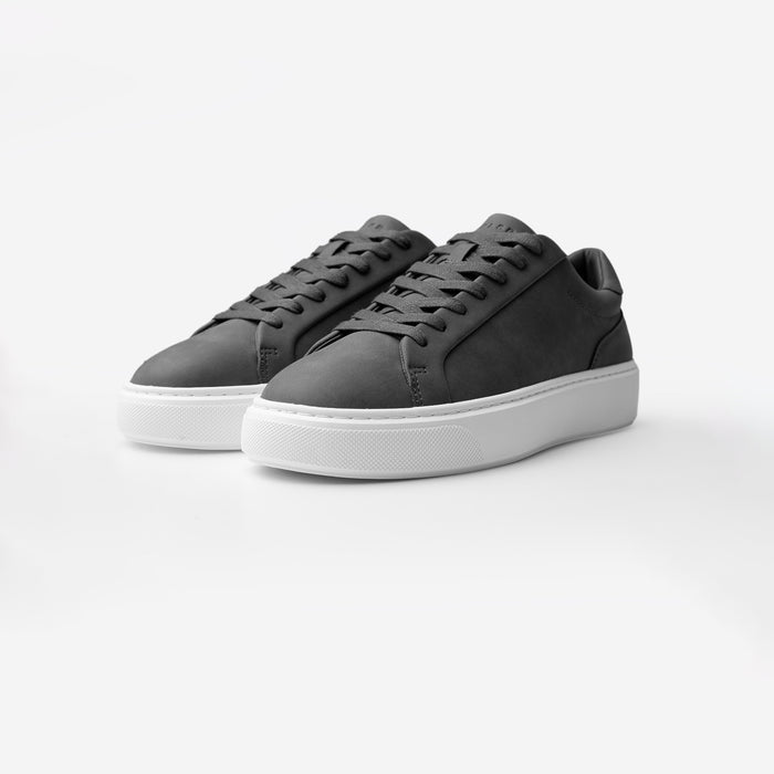 Three-quarter view of the Premium Classic Trainers in charcoal, featuring clean white PU uppers, charcoal lace-up fastening, charocal faux suede heel panels and cushioned cup soles.