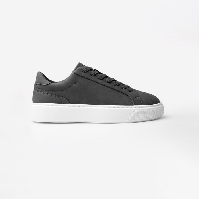 Side view of the Premium Classic Trainer in charcoal, featuring a clean white PU upper, charcoal faux suede heel, charcoal lace-up fastening and cushioned cup sole.