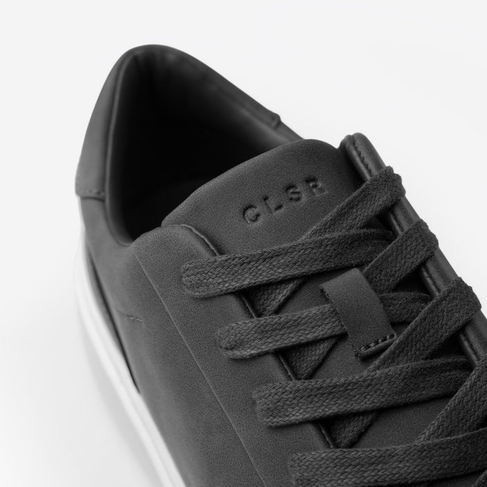 Close-up of the Premium Classic Trainer in charcoal, highlighting the charcoal textured laces, smooth PU upper and debossed CLSR tongue branding.