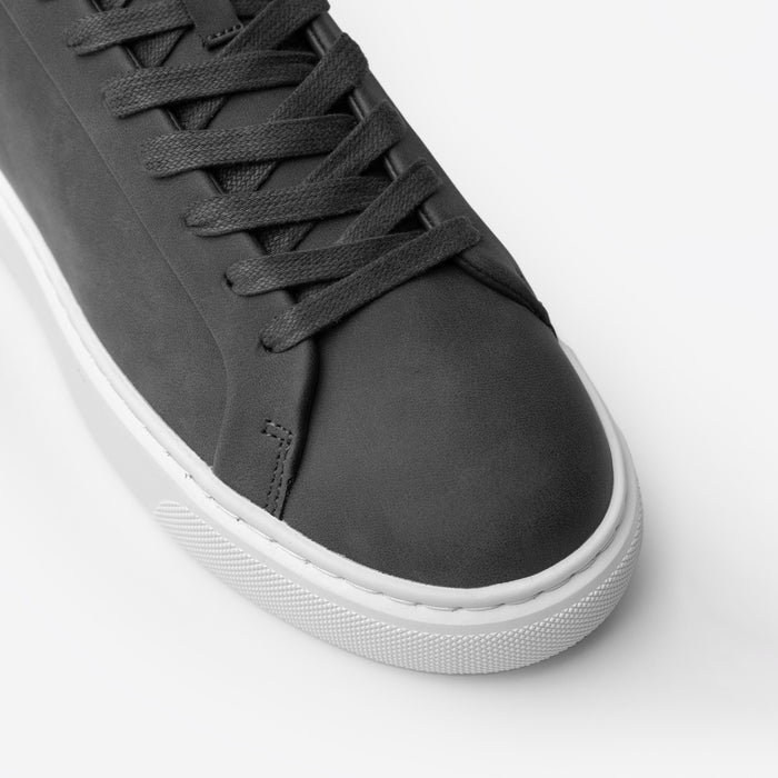 Close-up of the Premium Classic Trainer in charcoal, highlighting the smooth white PU toe box, tonal lace-up fastening, stitching and textured cup sole.