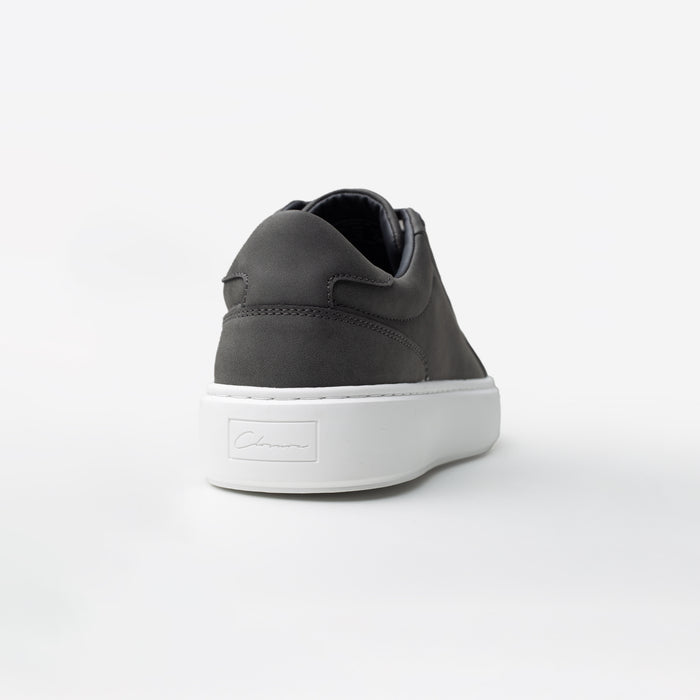 Rear view of the Premium Classic Trainer in charcoal, highlighting the cahrcoal faux suede heel panel and debossed Signature Closure London branding on the white cup sole.