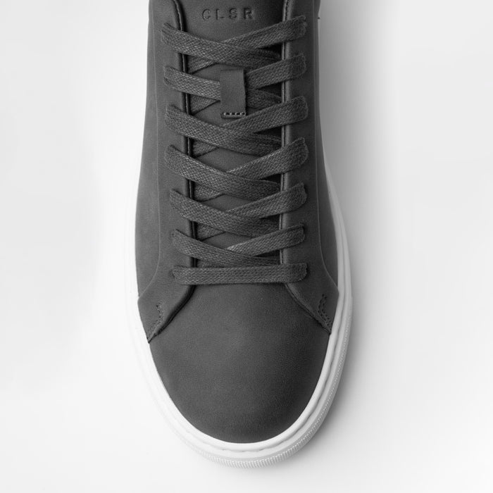 Close-up of the Premium Classic Trainer in charcoal, highlighting the smooth charcoal PU toe box, tonal lace-up fastening, stitching and textured cup sole.