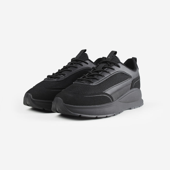 Pair of premium runner trainers in all black, shot on white background