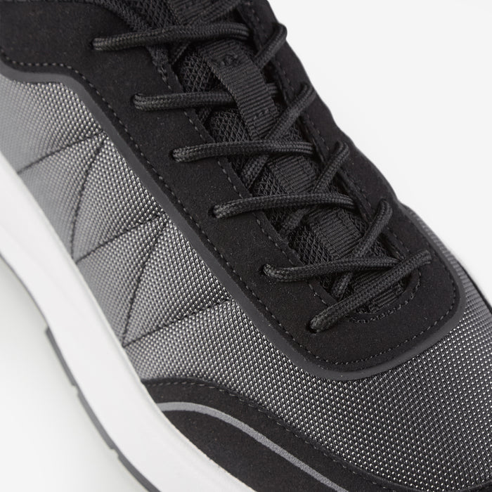 Close up shot of smart runner trainers in black focusing on black laces