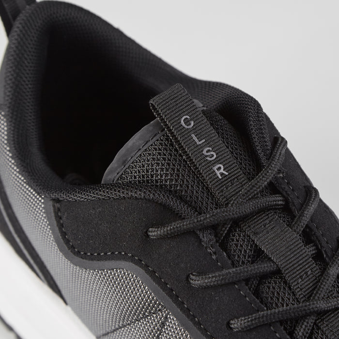Close up of runner trainers in black showing CLSR embroidery on tongue strap