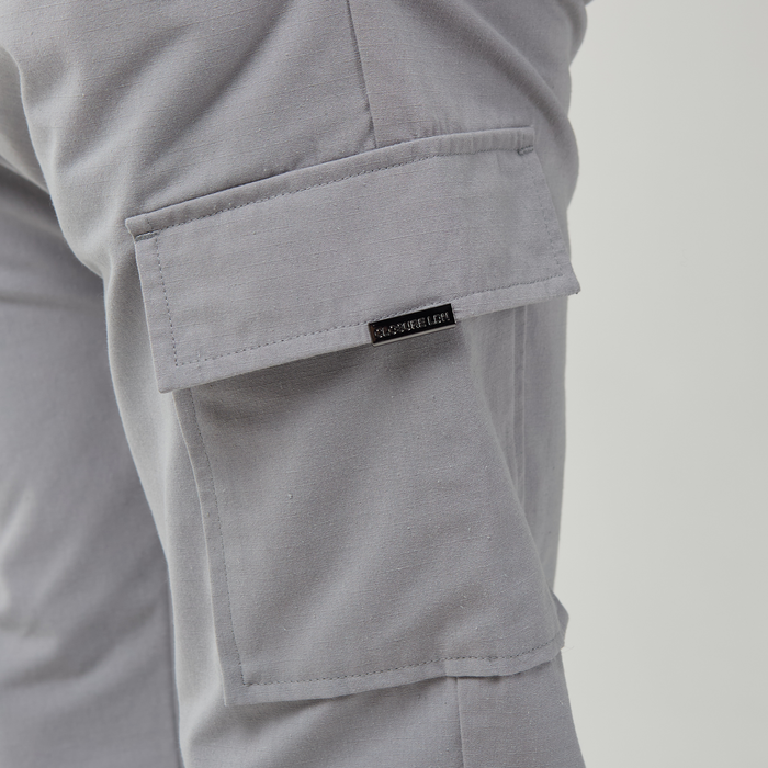 Close up of ice grey pocket with Closure London branded on cargo pants pocket