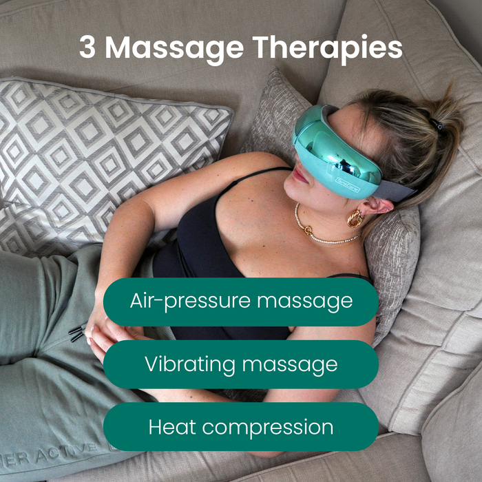 Woman reclining on grey sofa wearing teal TensCare OKO Eye Massager. Text: "3 Massage Therapies: Air-pressure massage, Vibrating massage, Heat compression"