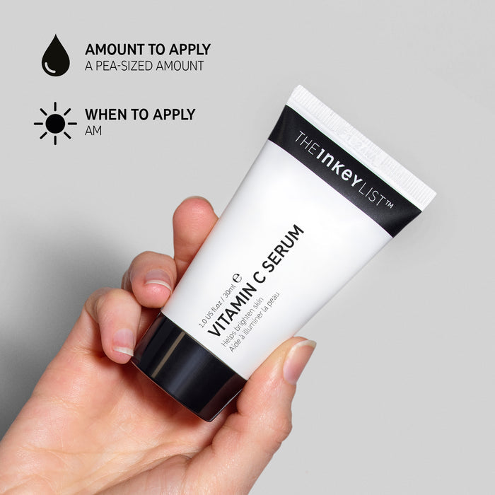 Hand holding a tube of Vitamin C Serum with how to apply instructions