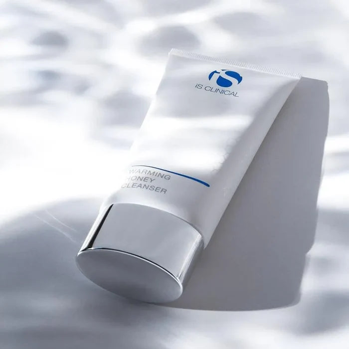iS Clinical Warming Honey Cleanser tube with silver cap on white surface with soft shadows